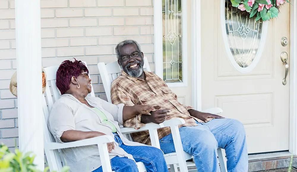 Senior African-American couple together on front porch 