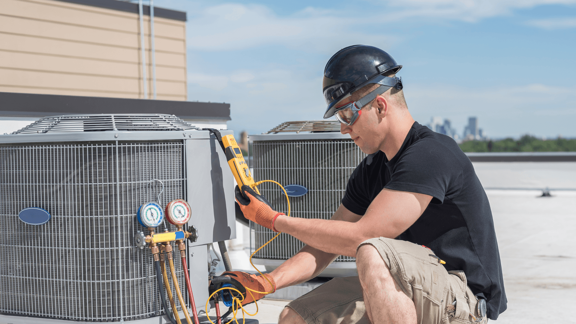 Man working on an HVAC system on a roof 