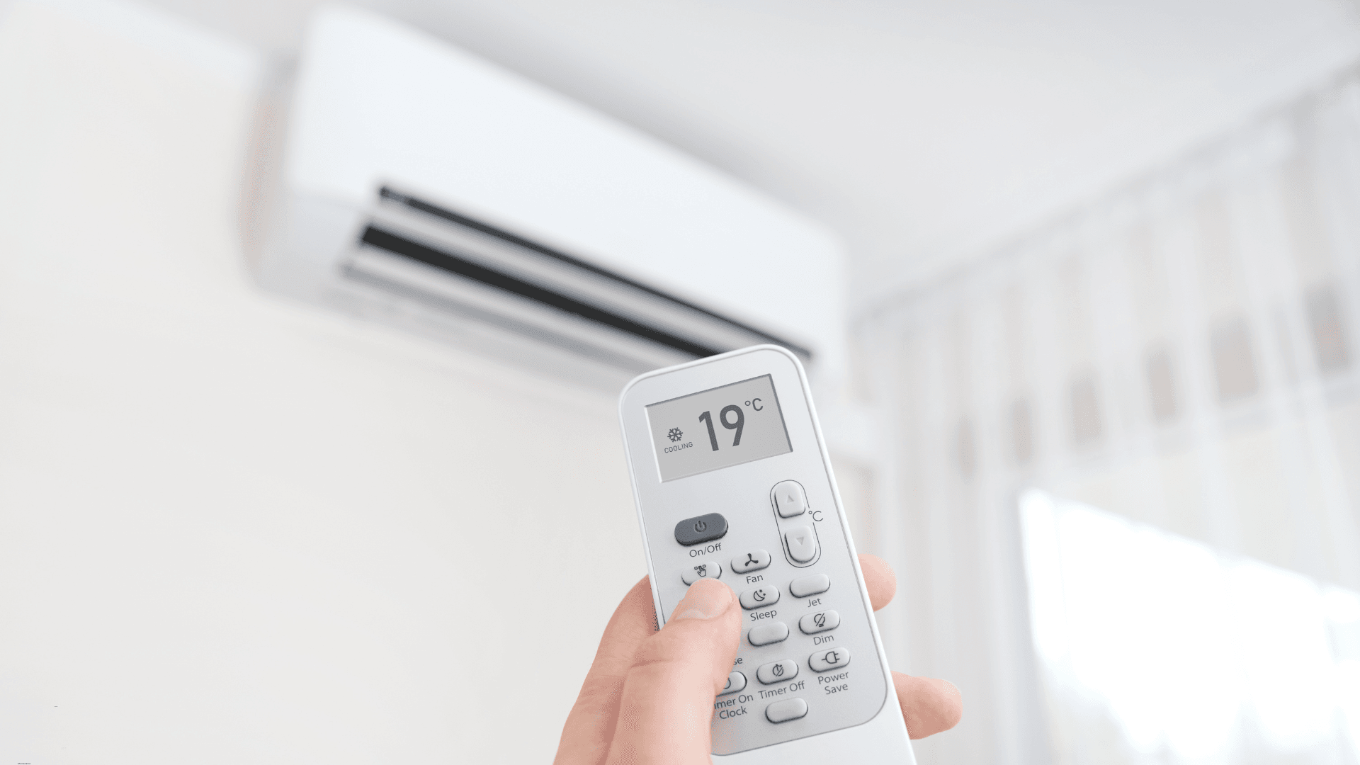 Someone using an air conditioner in their home with a remote 