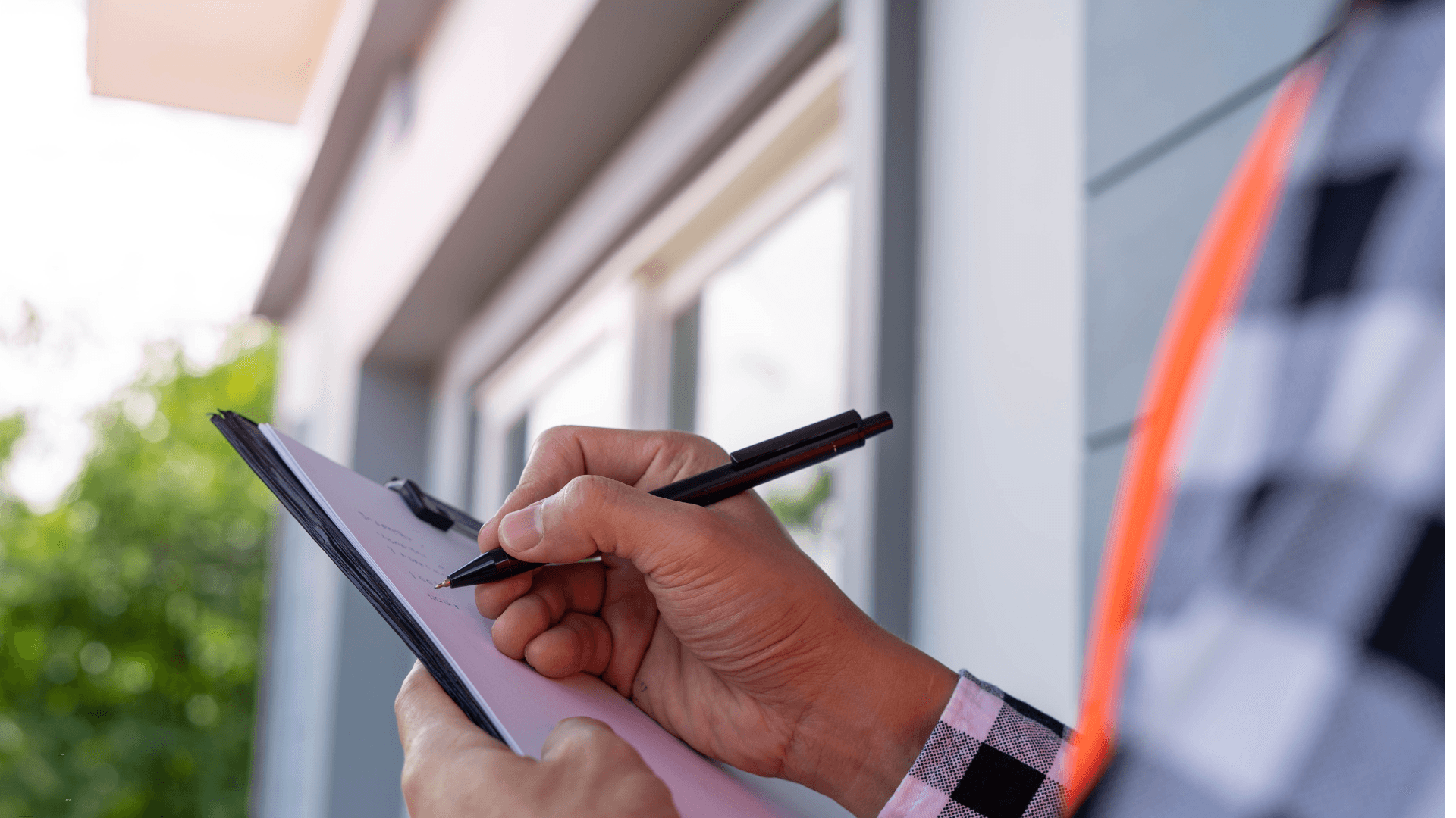 Man with a checklist outside his home 