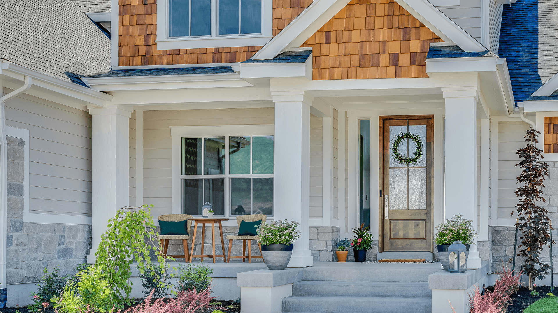 Beautiful house with wood panel, wreath on the door and inviting porch 