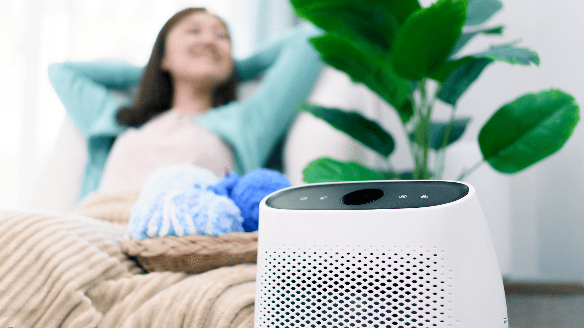 Woman sitting on a couch with an air purifier in front of her