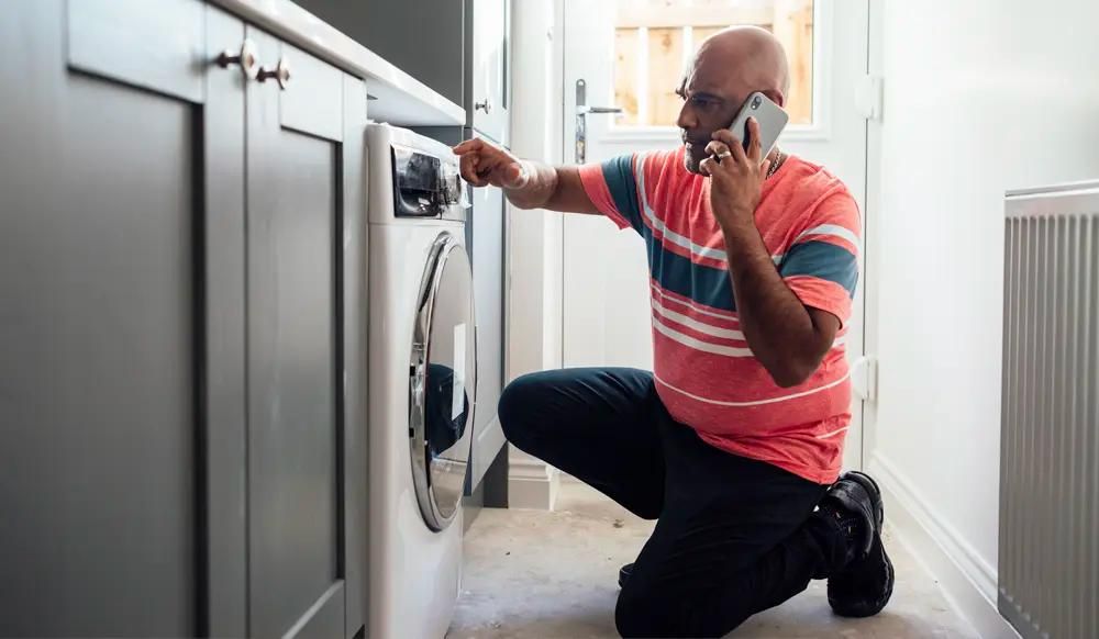 man on phone calling for washing machine repair